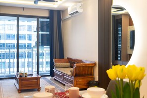 A modern living room with a sofa, coffee table, and a view of a cityscape through large windows. - 3BR Lsh33 KL Duke Highway Genting Free parking (Kuala Lumpur)