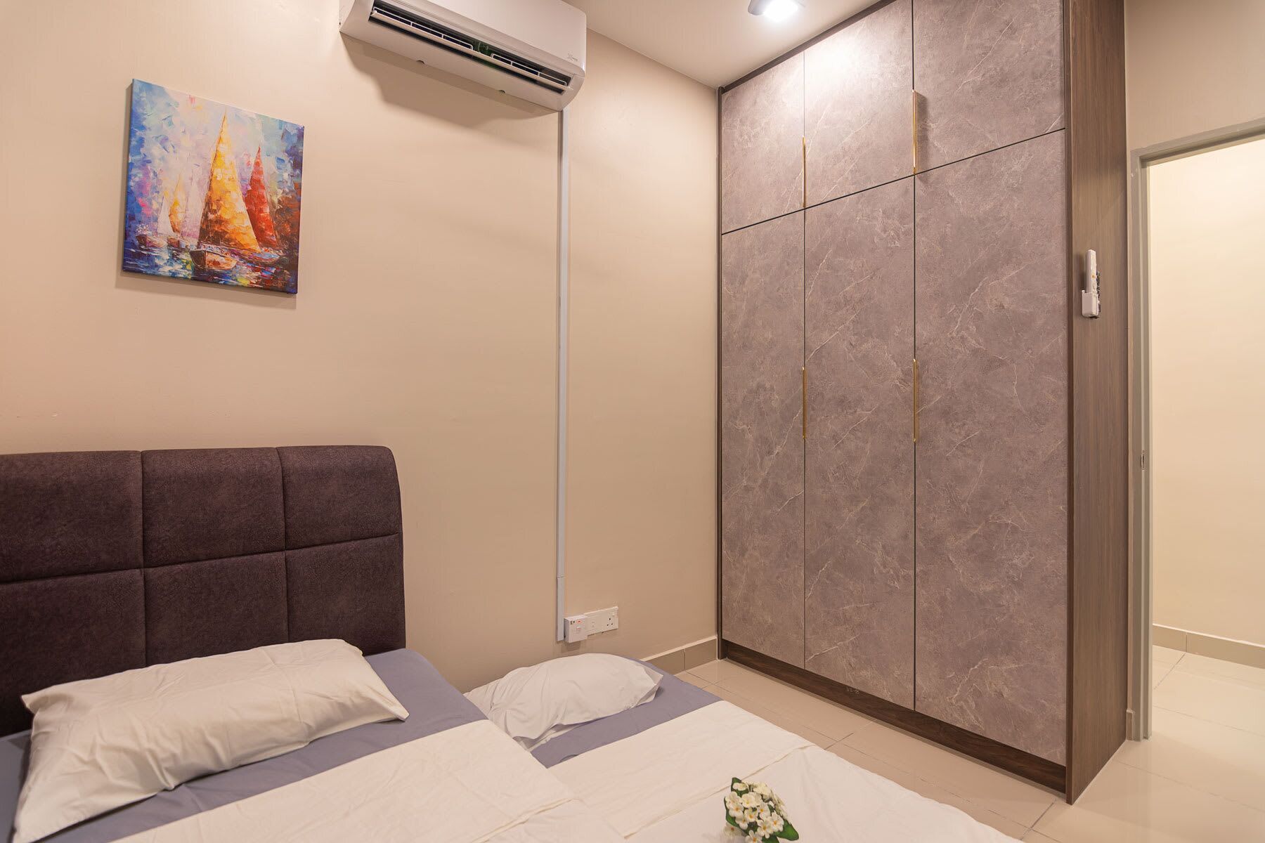 Une chambre à coucher comprenant un lit, une armoire et un appareil de climatisation.