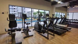 A gym with cardio machines, a rowing machine, and a bench press. - 3BR Lsh33 KL Duke Highway Genting Free parking (Kuala Lumpur)