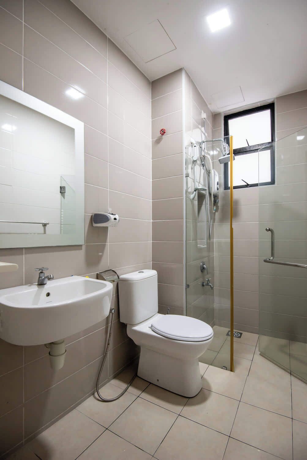 A modern bathroom with a sink, toilet, and glass shower enclosure.