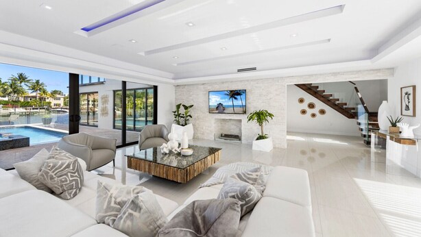 Un salon moderne avec vue sur la piscine, une cheminée et un escalier.