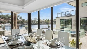 Un espace repas avec vue sur un port de plaisance et une piscine.