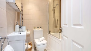 A modern bathroom with a glass-enclosed shower, a white toilet, and a bathtub. - Lovely 1BR near Big Ben & Buckingham Palace (London)