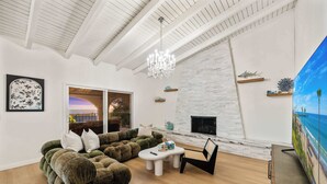A modern living room with a sectional sofa, a coffee table, a TV, and a fireplace.