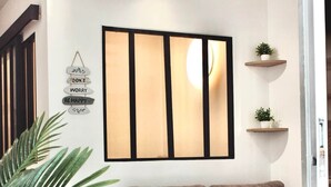 A modern living room with a brown sofa, a wooden coffee table, and a large plant. - Ti Cosy Gosier Swimming pool & beach (Le Gosier)