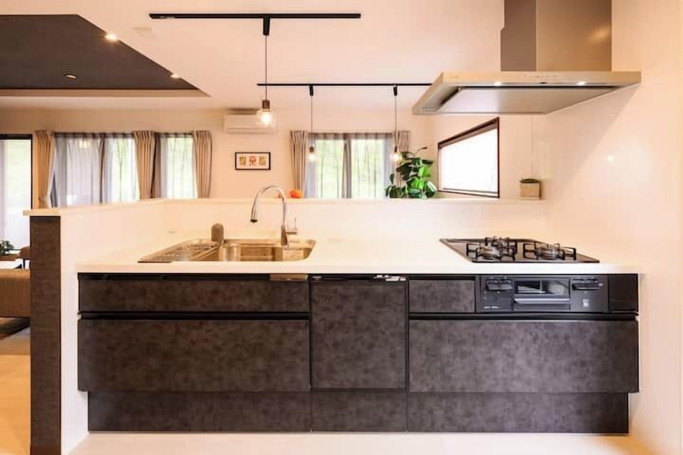 A modern kitchen with a central island, built-in dishwasher, and a gas stove.