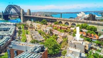 Vista aérea de un paisaje urbano con puntos de referencia destacados, como un puente y una gran ópera.