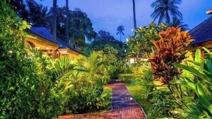 A tropical resort with a paved pathway leading to a building with a thatched roof. - Villa Waimarie | Lipa Noi Beachfront 6BR Villa — Pool & Chef (Surat Thani)