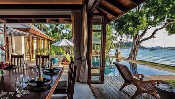 An outdoor dining area with a view of the water, wooden deck, and a covered seating area. - Villa Waimarie | Lipa Noi Beachfront 6BR Villa — Pool & Chef (Surat Thani)