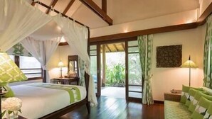 A bedroom with a canopy bed, a nightstand, a lamp, and a view of the outdoors. - Villa Waimarie | Lipa Noi Beachfront 6BR Villa — Pool & Chef (Surat Thani)