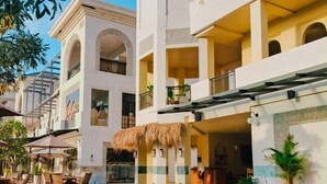 A hotel with a pool, outdoor seating, and a thatched-roof bar area. - Montana Oceanside Mandalika (Central Lombok Regency)
