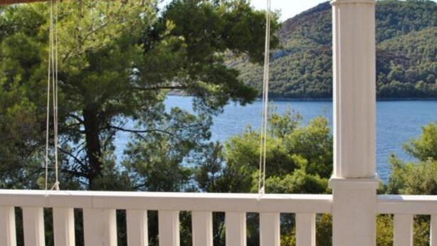 A wooden deck with a view of a lake and hills. - Apartments Maritimo (Smokvica)