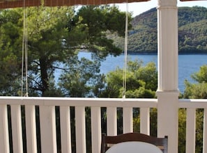 Une terrasse en bois offrant une vue sur un lac et des collines.