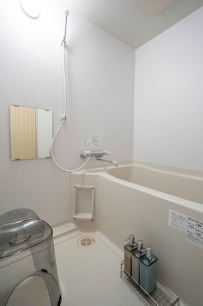 A bathroom with a bathtub, a shower, and a washing machine. - LAMBRUSCO (Kamifurano)