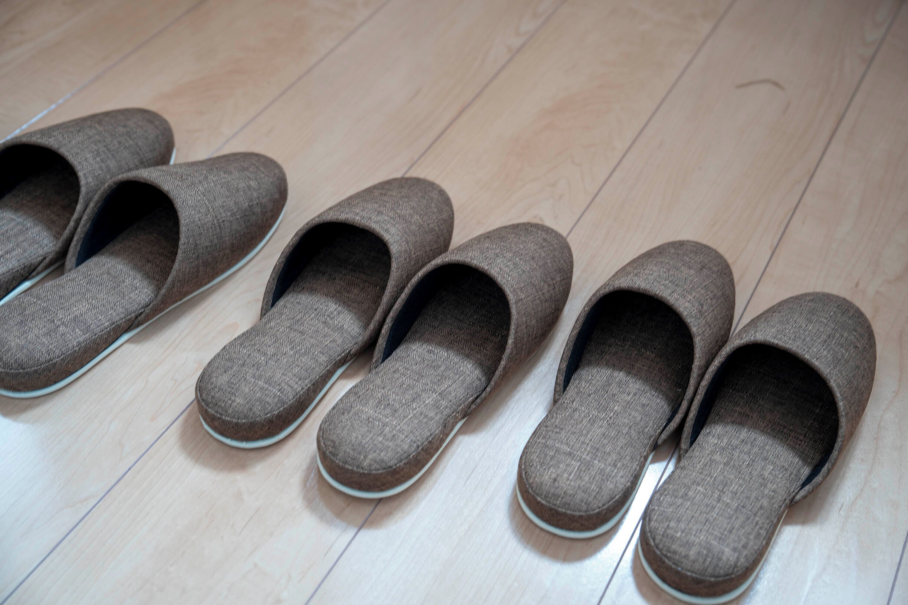Un par de zapatillas marrones sobre un piso de madera.