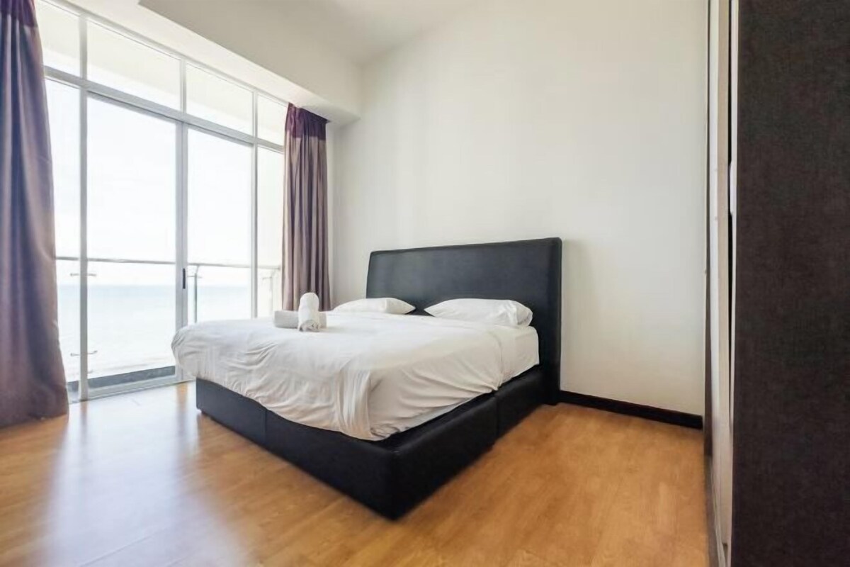 A bedroom with a bed, a large window, and a view of the outdoors.