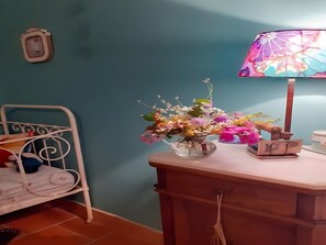 A room with a bed, a bedside table with a lamp, and a wall-mounted phone.