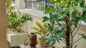 A wooden deck with a table and chairs, surrounded by potted plants and decorative items. - Luxury 4 bedroom Solar Villa (Phu Quoc)