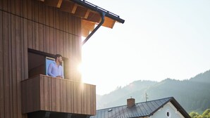 A wooden building with a balcony and a sign reading "SCHLADMING". - Hotel UND smart alpine stay (Schladming)