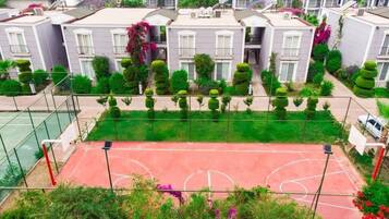 A residential area with multiple two-story houses, a basketball court, and well-maintained gardens.