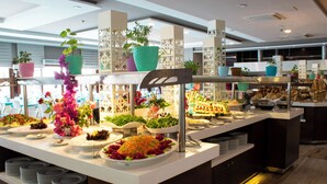 A buffet setup with various food items and decorative plants. - Doramar Resort Aqua Tatilkoyu (Erdemli)