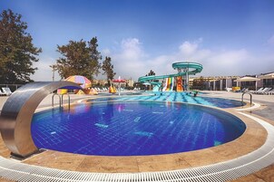 Una piscina techada, una piscina al aire libre de temporada, sombrillas