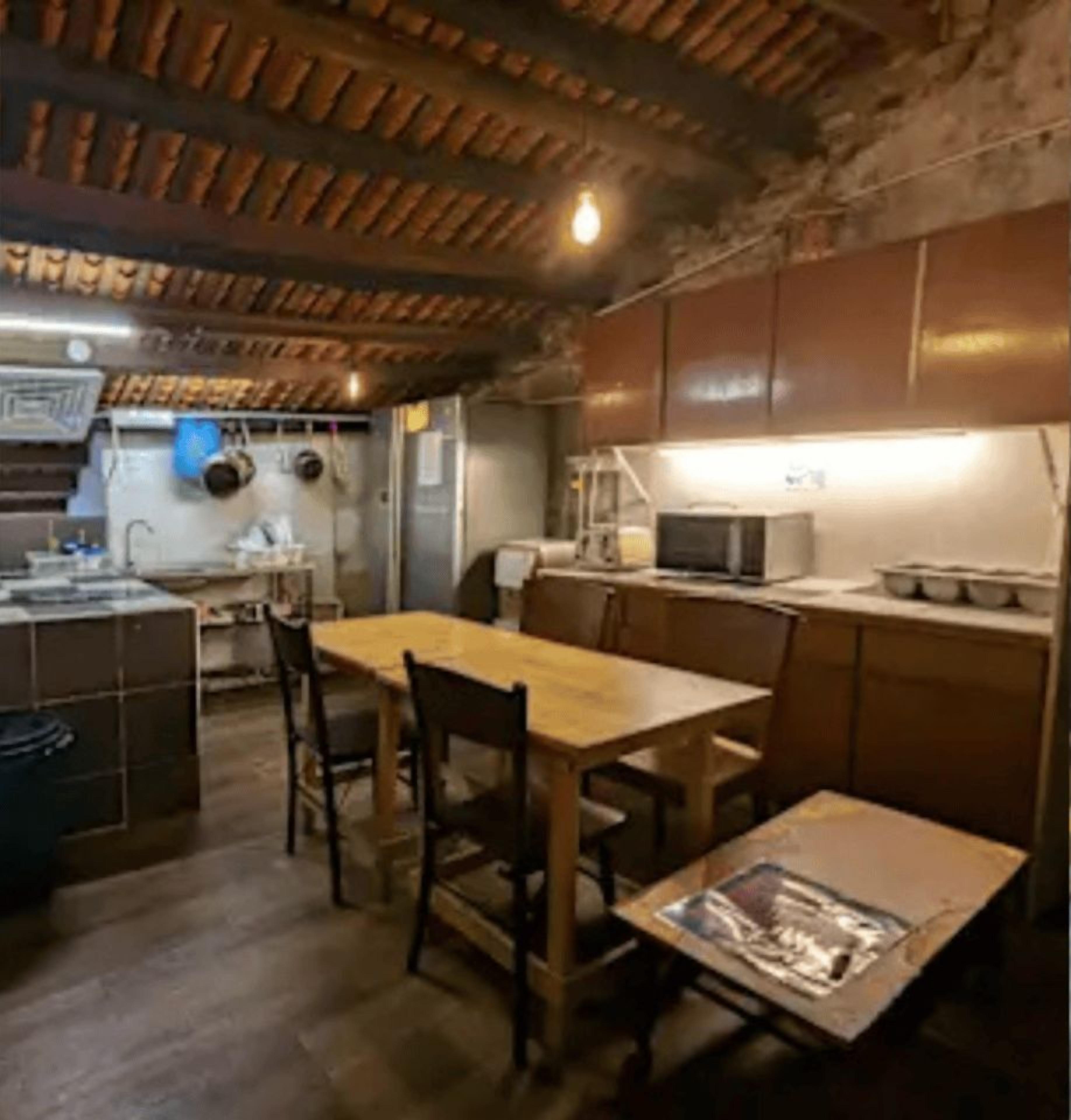 A fully equipped pantry with wooden cabinets, a sink, and a microwave.