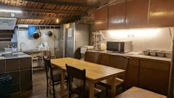 A fully equipped pantry with wooden cabinets, a sink, and a microwave.