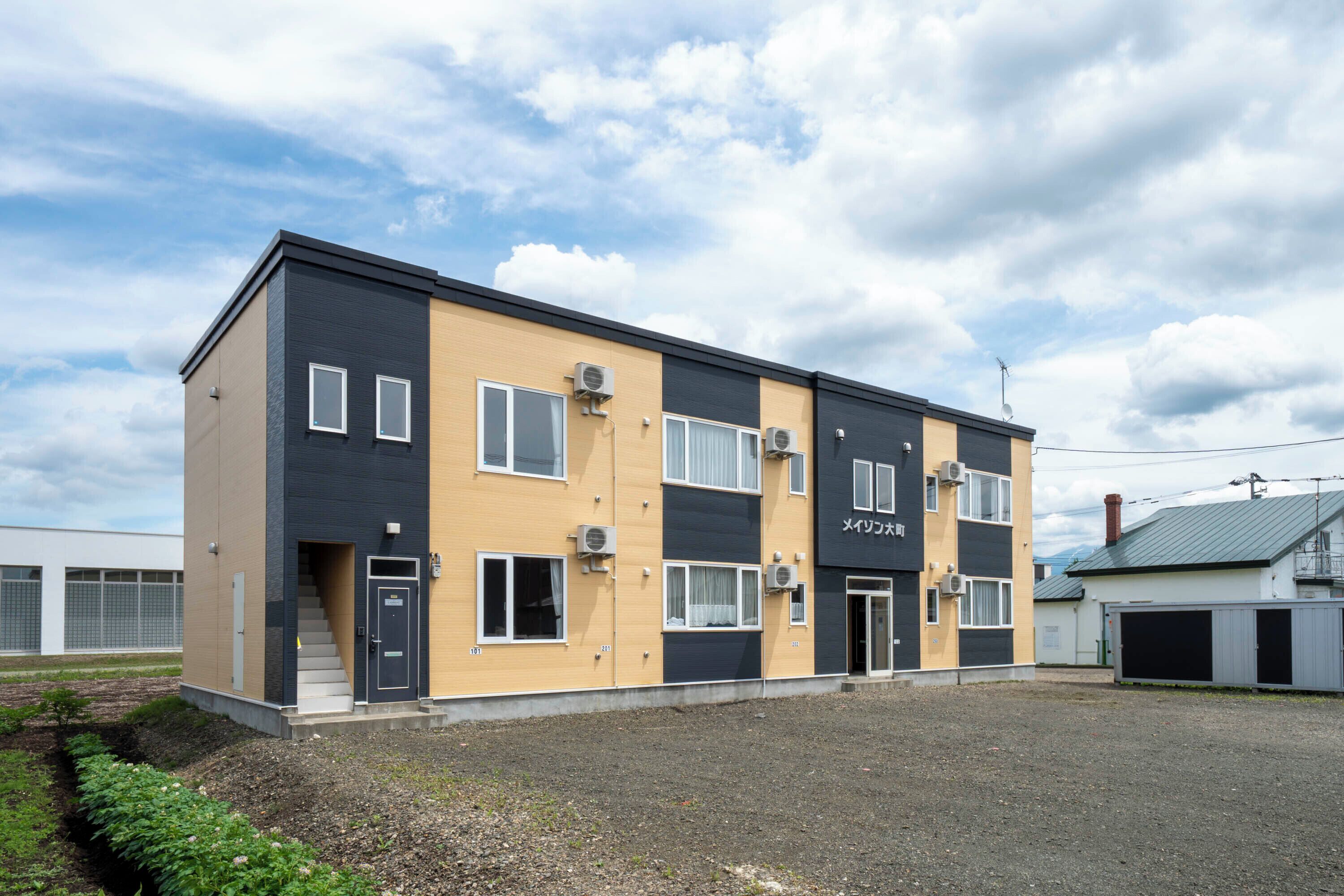 Un edificio de varios pisos con techo plano, varias ventanas y unidades de aire acondicionado.