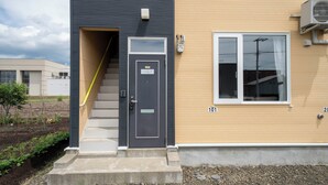 Un bâtiment moderne avec une porte grise portant l’inscription « LAMBERT » et une fenêtre sur laquelle est inscrit le numéro « 101 ».