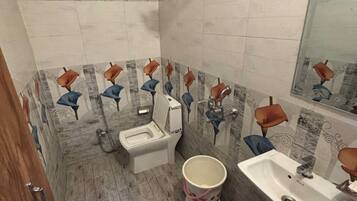 Un baño con inodoro, bidé, lavabo y ducha.