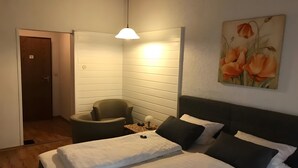 A bedroom with a bed, a chair, a desk, and a painting on the wall. - Hotel Schachten – Apartment 3 mit Bergblick, Frühstück inklusive & Shuttleservice (Lindberg)