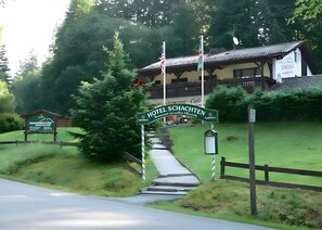 A hotel entrance with a sign, pathway, and surrounding greenery. - Hotel Schachten – Apartment 4 mit Bergblick, Frühstück und Shuttle-Service (Lindberg)