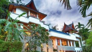 A two-story house with a traditional architectural style, featuring a stone facade and multiple gables.