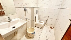 Un baño con lavamanos, inodoro y ducha.