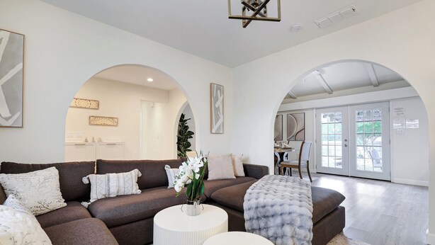 A modern living room with a sectional sofa, a round coffee table, and a large window with a view of the outdoors.