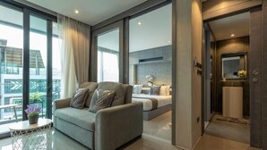 A modern hotel room with a sofa, a bed, and a bathroom. - Steps to Kamala Beach Rooftop Pool  C138 (Kamala)
