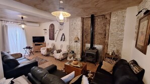 Una sala de estar acogedora con chimenea, sofás de cuero y una televisión.