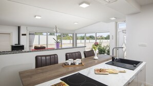 A modern kitchen with a large island, built-in appliances, and a view of the outdoors. - Holiday Estate Stancija Matošić in Medulin (Medulin)