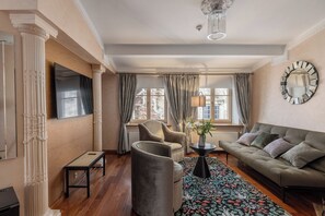 Suite superior, vistas a la ciudad | Zona de estar | Una televisión