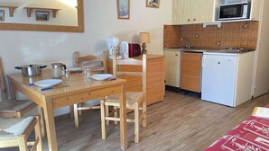 A compact kitchen with a microwave, a small refrigerator, and wooden cabinets. - Mountain studio 4 pers, South, Ski-in/out (Risoul)