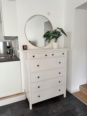 A white dresser with a round mirror and a potted plant. - JUPAS° Saartal Suite – Quiet, Playground & Parking (Konz)