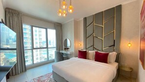 A modern hotel room with a large bed, a desk, a chair, and a view of the city. - Durrani Homes - The Residences 5BR Besides Dubai Mall with Burjkhalifa and Fountain view (Dubai)