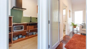 A compact kitchen with a microwave, oven, and cabinets. - Drift Studio - Cosy Fremantle Hideaway (Beaconsfield)
