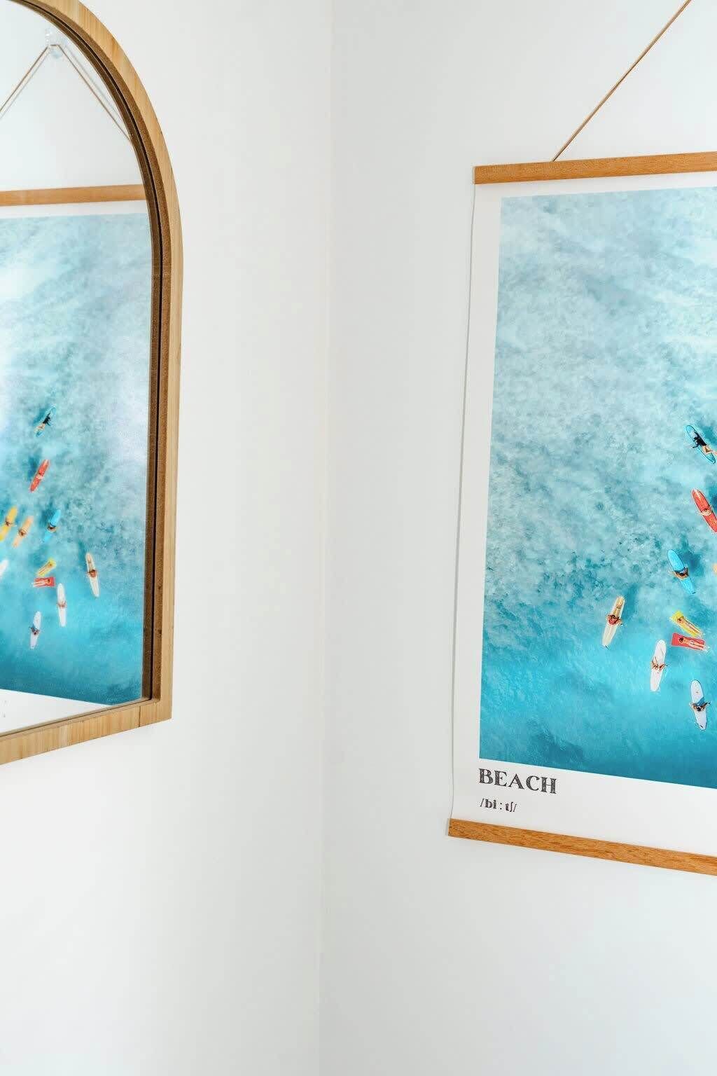 A framed artwork depicting a beach scene with surfboards and the word "BEACH" at the bottom.