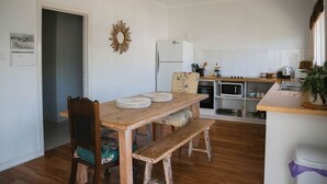 Une cuisine de taille réduite avec une table à manger en bois, un réfrigérateur et un four à micro-ondes.