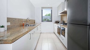 A modern kitchen with granite countertops, stainless steel appliances, and a window providing natural light. - Wonderful Warrawee with Parking and backyard (Warrawee)