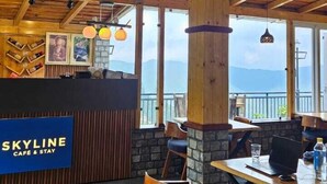 Un interior de madera con una mesa de recepción que dice "SKYLINE CAFE & STAY".