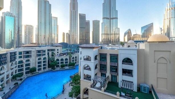 Una zona urbana moderna con edificios altos, una piscina central y una combinación de arquitectura residencial y comercial.