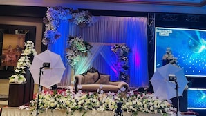 A stage with a sofa, floral arrangements, and a DJ setup. - Hotel A9 Resorts (Raikot)